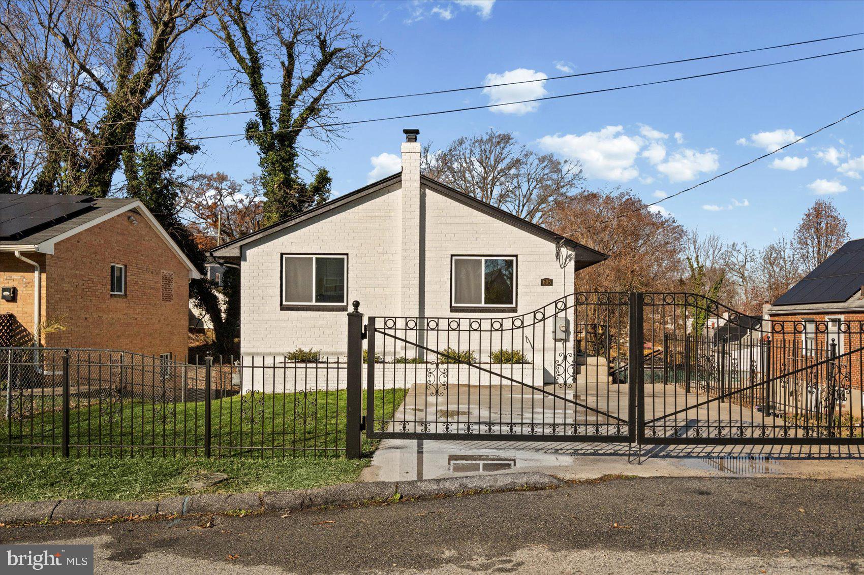 605 Elfin Avenue Capitol Heights, MD 20743 - Photo 2 of 42 a view of a white house with a small yard and large trees