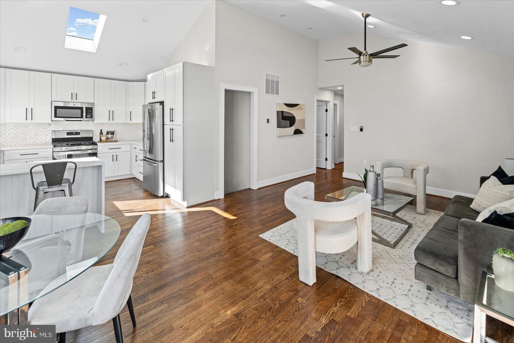 605 Elfin Avenue Capitol Heights, MD 20743 - Photo 8 of 42 a kitchen with stainless steel appliances granite countertop a refrigerator a stove a sink a dining table and chairs with wooden floor