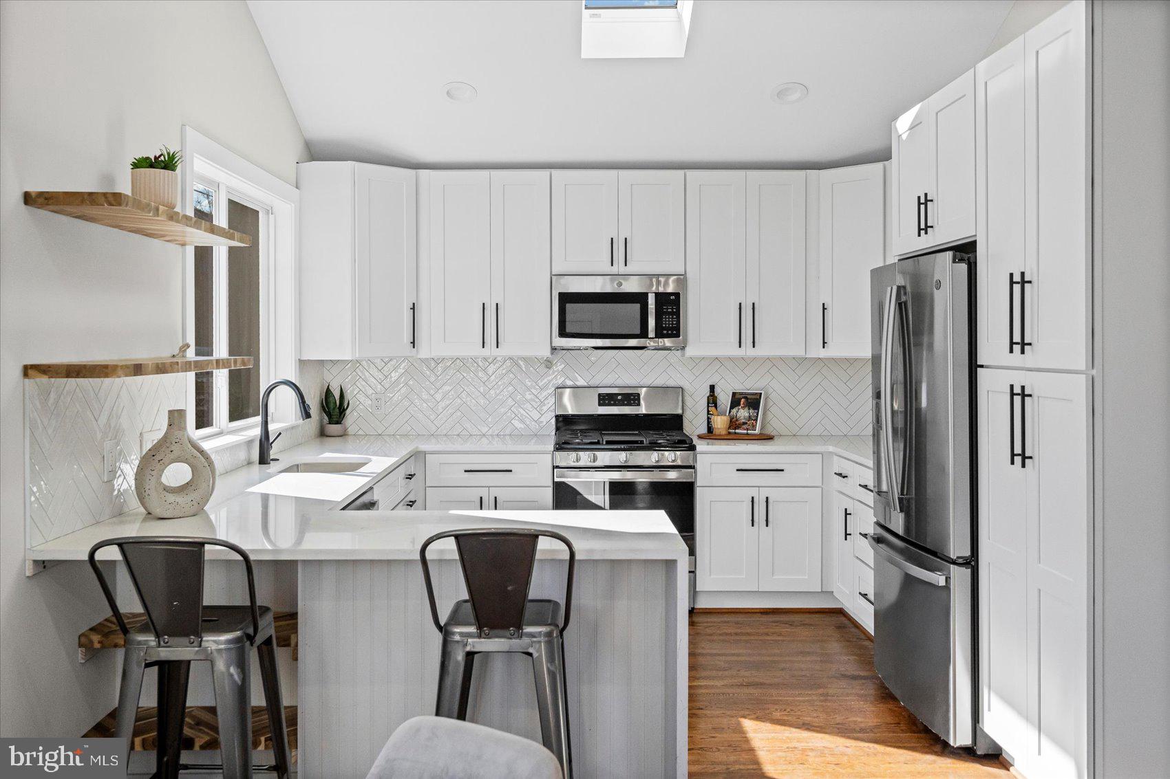 605 Elfin Avenue Capitol Heights, MD 20743 - Photo 9 of 42 a kitchen with stainless steel appliances a refrigerator stove microwave and cabinets