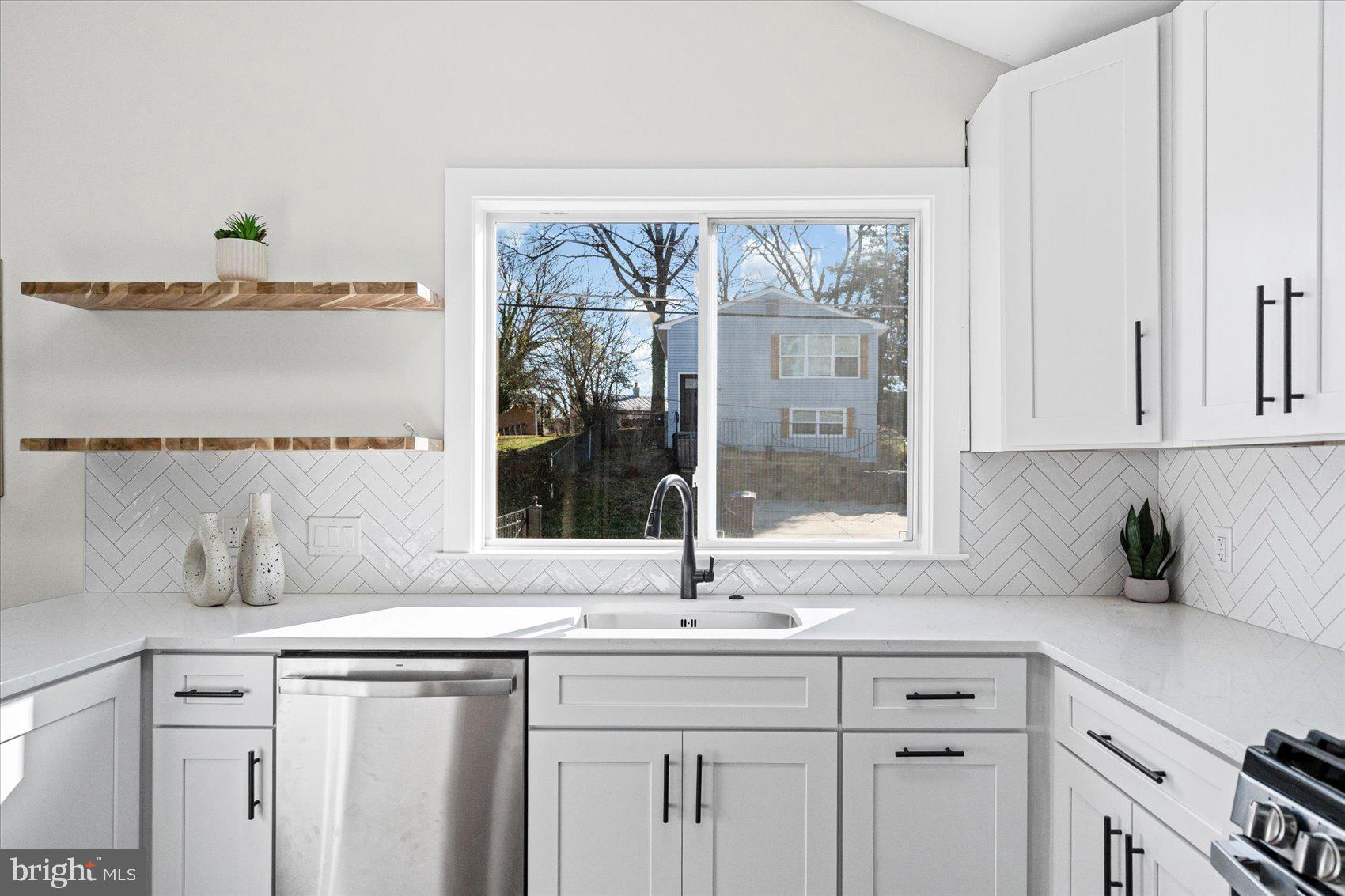 605 Elfin Avenue Capitol Heights, MD 20743 - Photo 10 of 42 a kitchen with stainless steel appliances white cabinets and a window