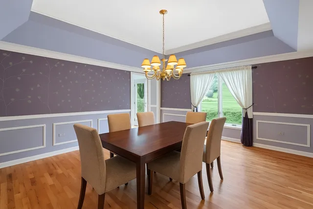 a dining room with furniture a chandelier and wooden floor
