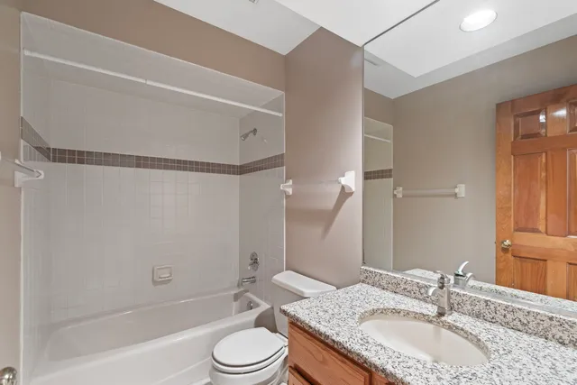 a bathroom with a granite countertop sink toilet and shower