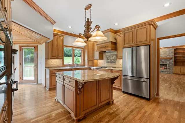 a kitchen with stainless steel appliances granite countertop a refrigerator a sink and a stove