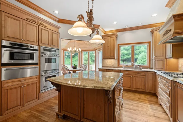 a kitchen with stainless steel appliances granite countertop a sink a stove and a refrigerator