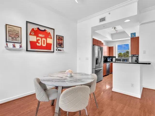 a view of a dining room with furniture wooden floor and a kitchen