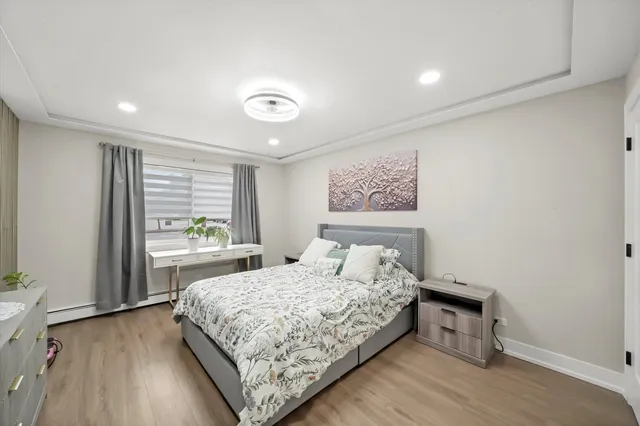 a bedroom with a flat screen tv a bed and wooden floor