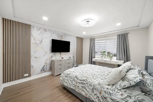 a bedroom with a large bed and a chandelier