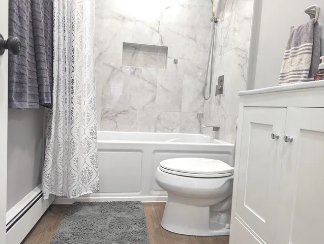 a bathroom with a sink a mirror a toilet and bathtub