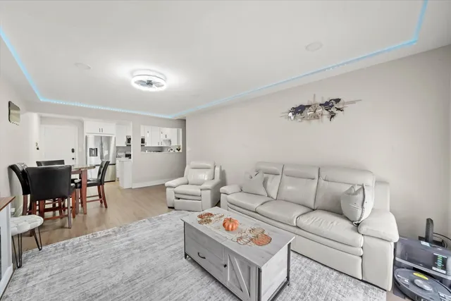 a living room with furniture and a dining table with chair