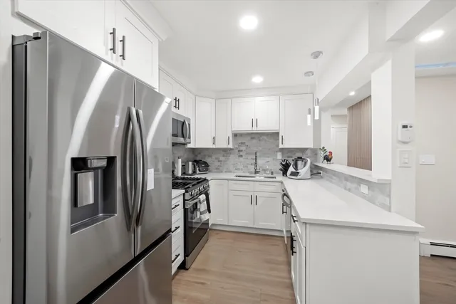 a kitchen with stainless steel appliances granite countertop a sink stove a microwave and cabinets