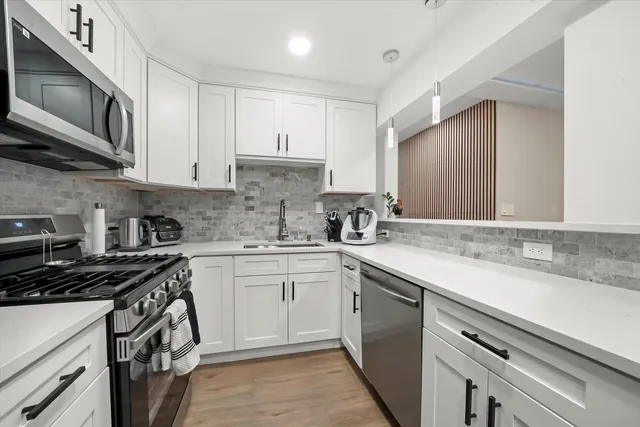 a kitchen with stainless steel appliances granite countertop a sink stove microwave and cabinets