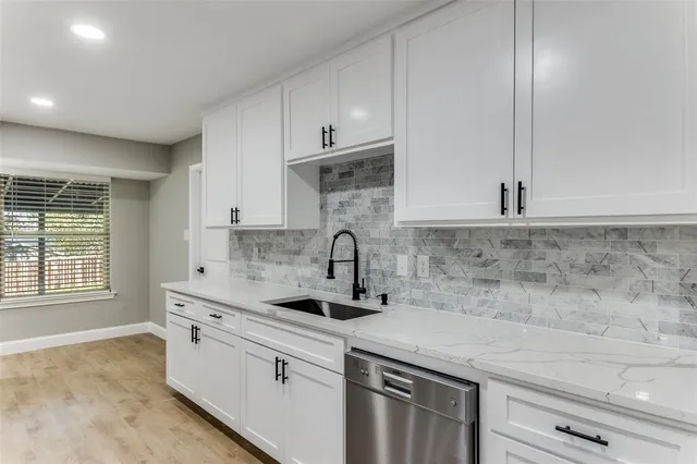 a kitchen with granite countertop a sink and cabinets