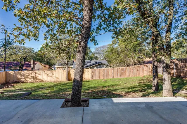 a view of backyard with barn and large trees
