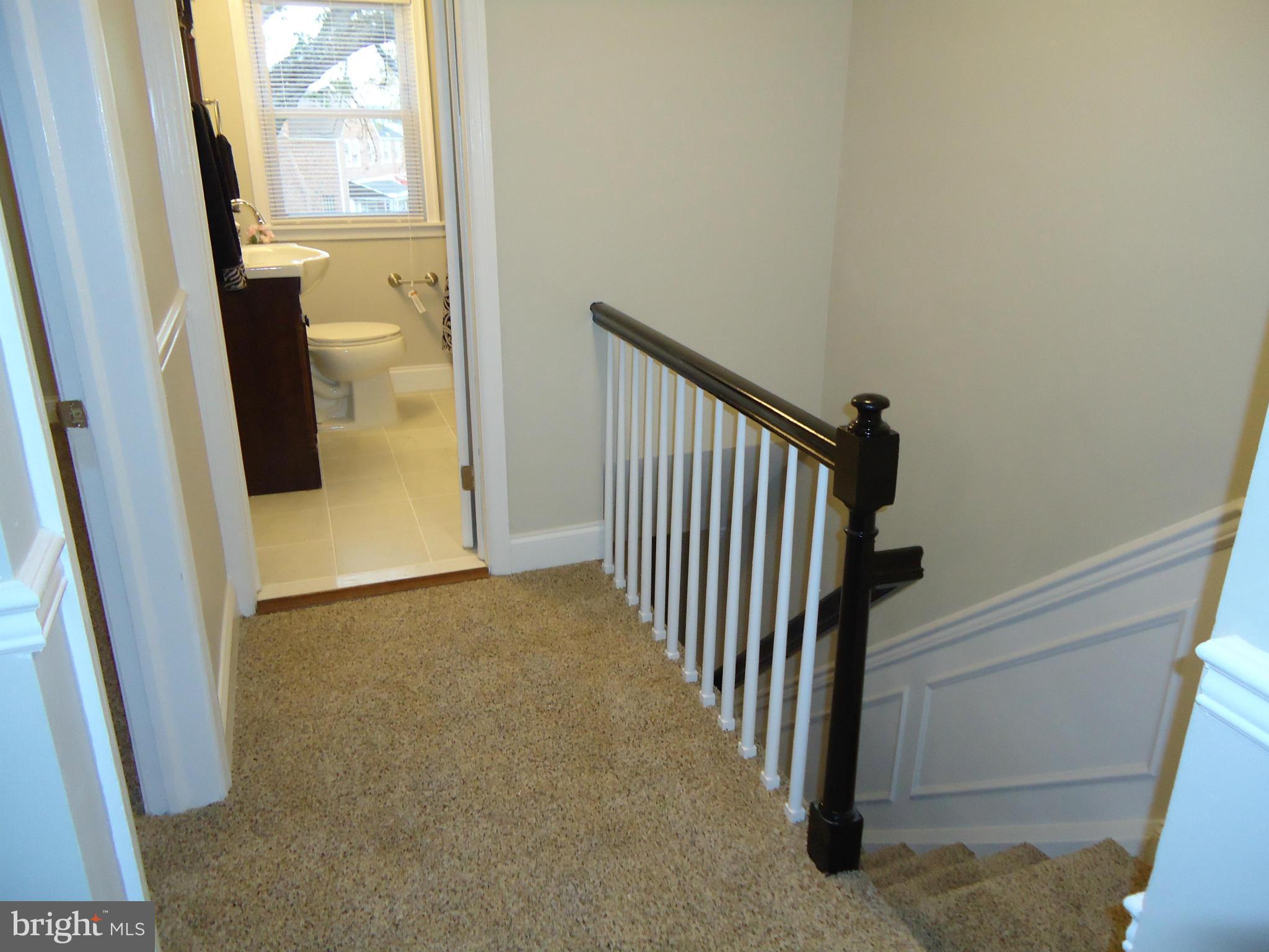 5720 Maplehill Road Baltimore, MD 21239 - Photo 22 of 25 a view of a hallway with wooden floor and stairs