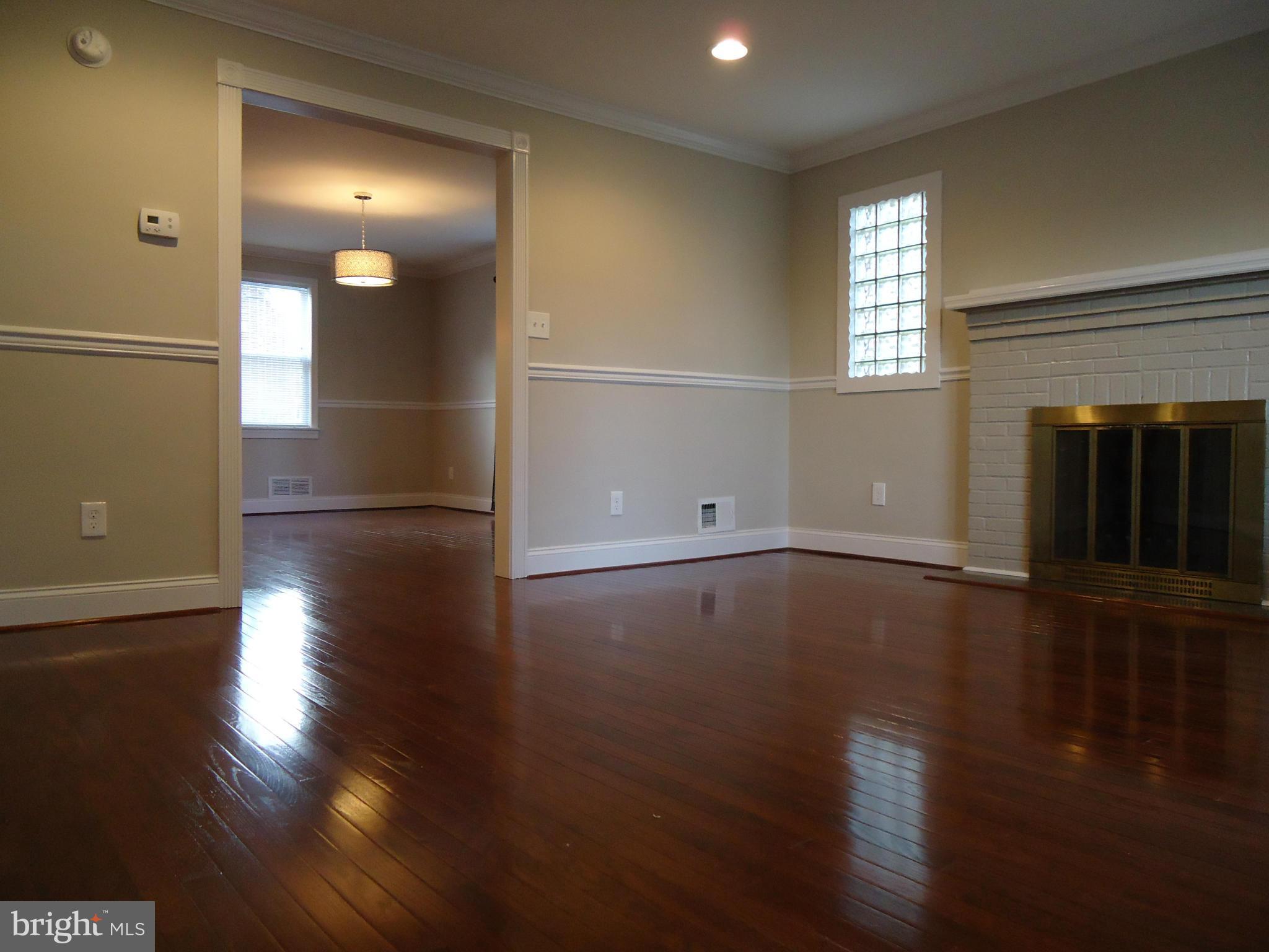 5720 Maplehill Road Baltimore, MD 21239 - Photo 5 of 25 an empty room with wooden floor and windows