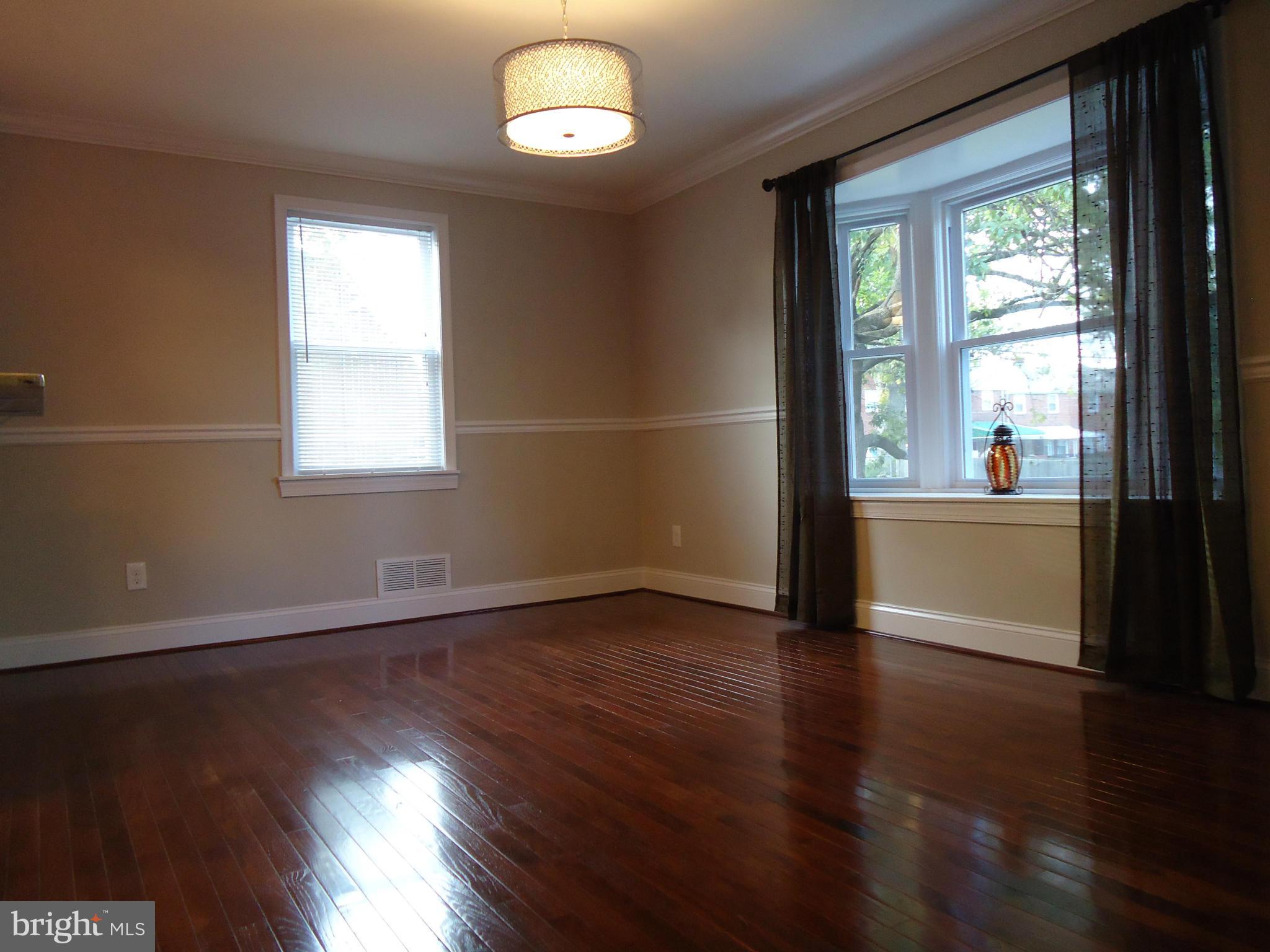 5720 Maplehill Road Baltimore, MD 21239 - Photo 6 of 25 an empty room with wooden floor and windows