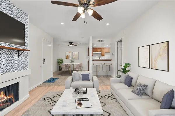 a living room with furniture a flat screen tv and a fireplace