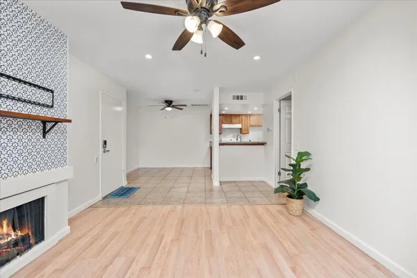 a view of empty room with wooden floor and fireplace