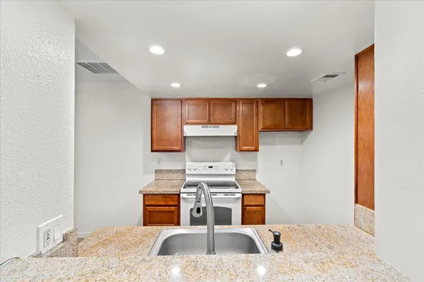 a kitchen with a refrigerator sink and cabinets