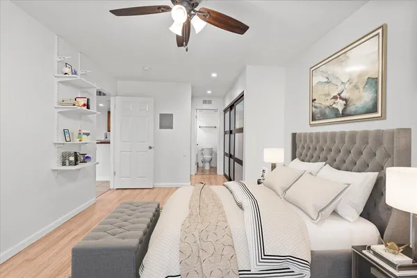 a bedroom with a large bed and a chandelier