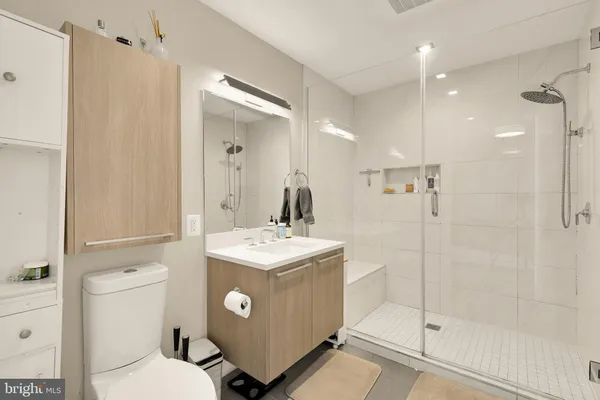 a bathroom with a sink a toilet a mirror and shower