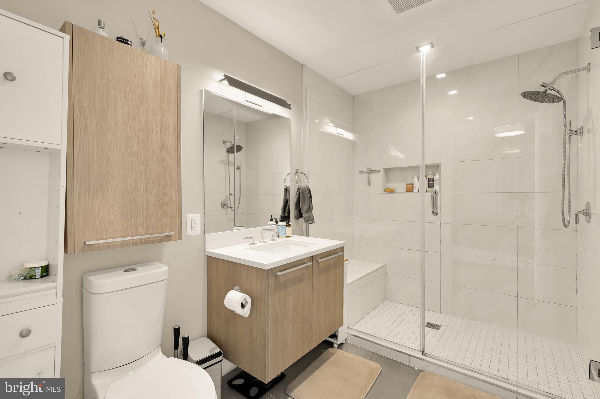 1628 11th Street Northwest, Unit 308 Washington, DC 20001 - Photo 17 of 26 a bathroom with a sink a toilet a mirror and shower