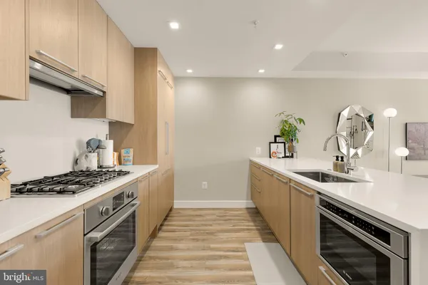 a kitchen with stainless steel appliances a sink stove and cabinets
