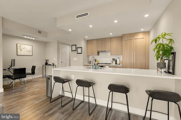 a kitchen with stainless steel appliances granite countertop a refrigerator and a dining table