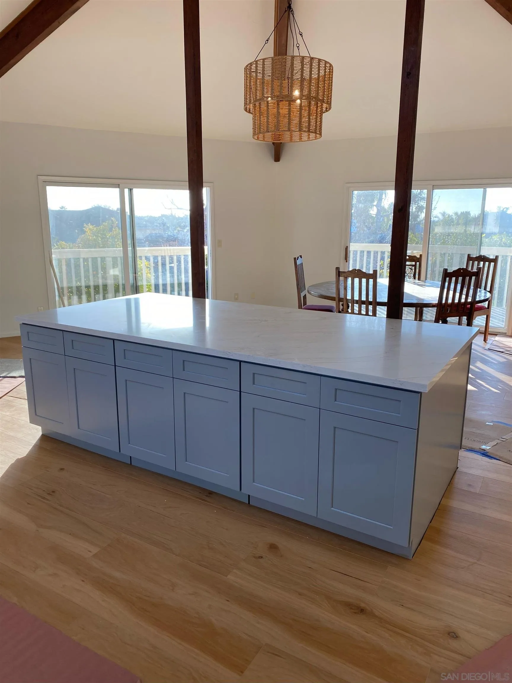 a view of a room with kitchen island stainless steel appliances wooden floor and a large window