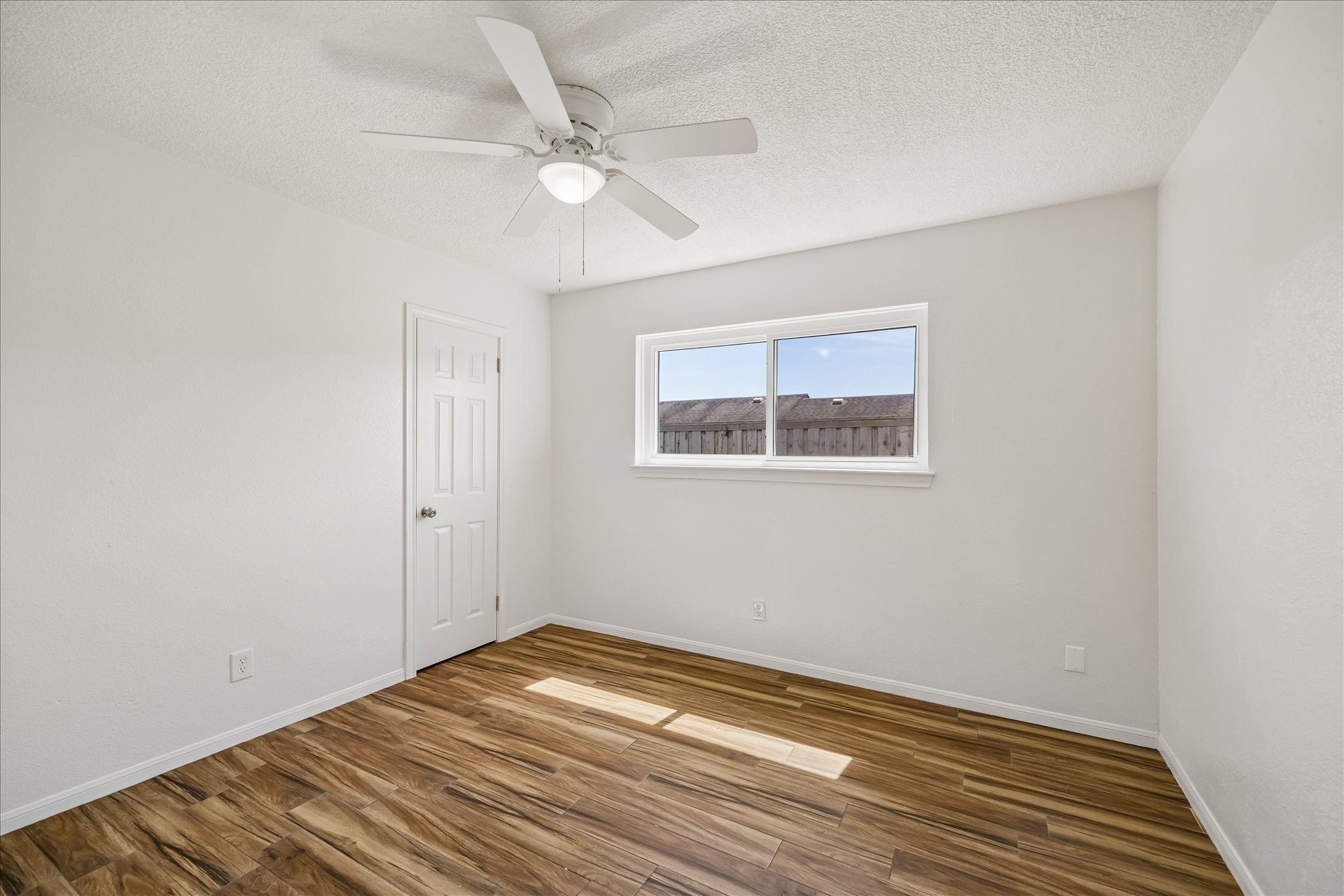 631 Lexington Square Humble, TX 77338 - Photo 16 of 22 This room features hardwood flooring, a ceiling fan, and a large window that provides ample natural light. The walls are painted in a neutral color, and there's a single door for entry. Perfect for a bedroom or office space.