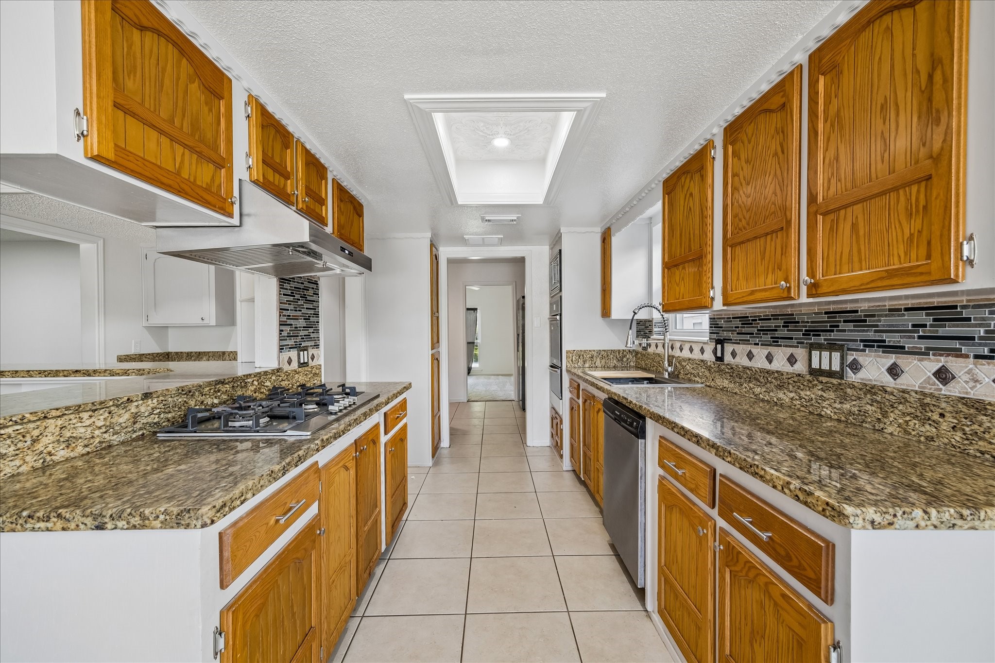 631 Lexington Square Humble, TX 77338 - Photo 9 of 22 Experience culinary luxury in this kitchen, featuring abundant cabinetry, sleek stainless appliances, a gas cooktop, and elegant granite countertops.