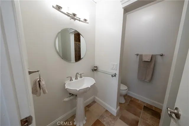 a bathroom with a sink and mirror with toilet