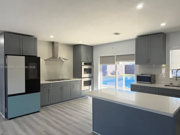 a kitchen with stainless steel appliances granite countertop a refrigerator and a sink