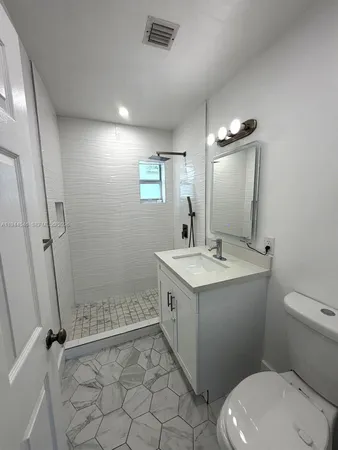 a bathroom with a granite countertop sink toilet and shower