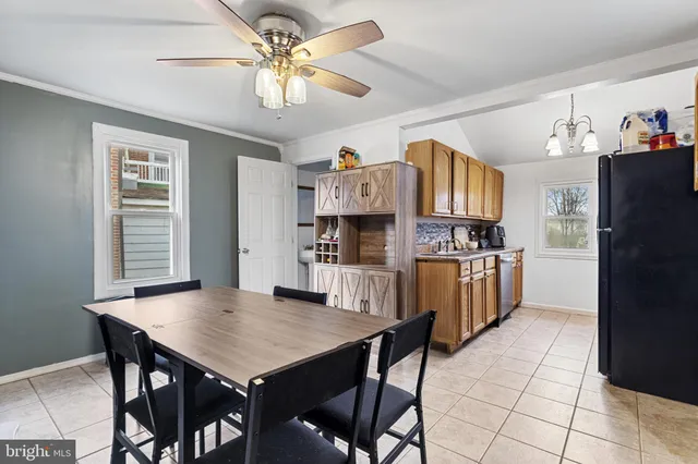 a kitchen with stainless steel appliances a table chairs and a refrigerator