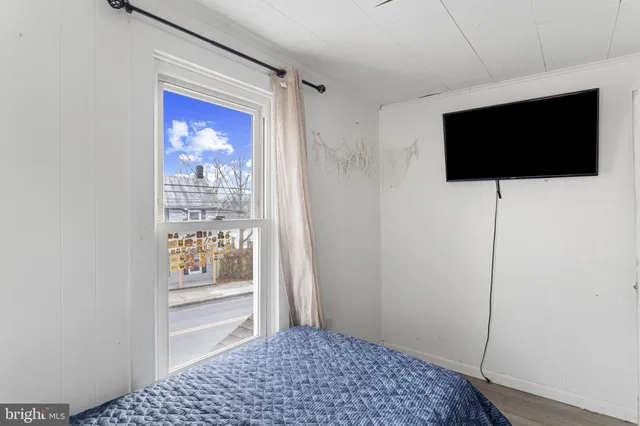 a view of a bedroom with wooden floor cabinet and a flat screen tv