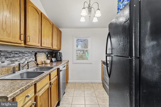 a kitchen with stainless steel appliances granite countertop a refrigerator a sink dishwasher with a stove and refrigerator