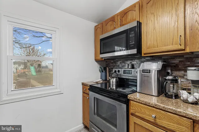 a kitchen with stainless steel appliances granite countertop a stove microwave and cabinets