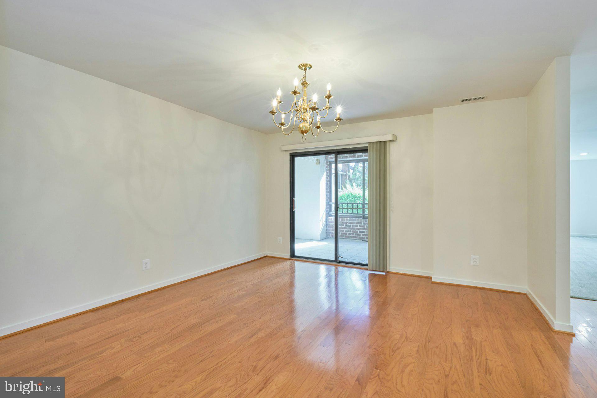 11500 Fairway Drive, Unit 101 Reston, VA 20190 - Photo 16 of 40 a view of an empty room with a window and wooden floor