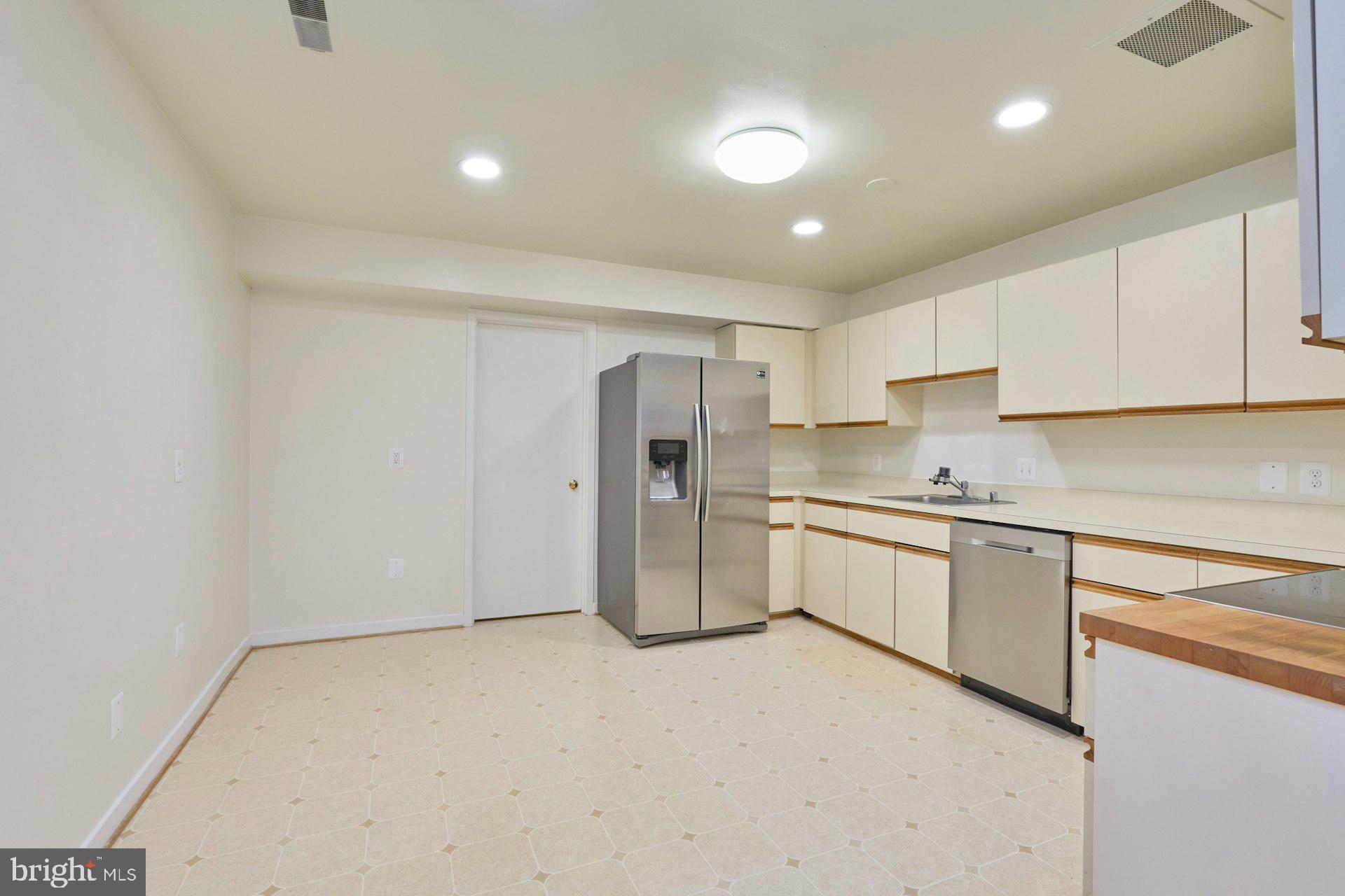 11500 Fairway Drive, Unit 101 Reston, VA 20190 - Photo 22 of 40 a kitchen with a refrigerator a sink and cabinets