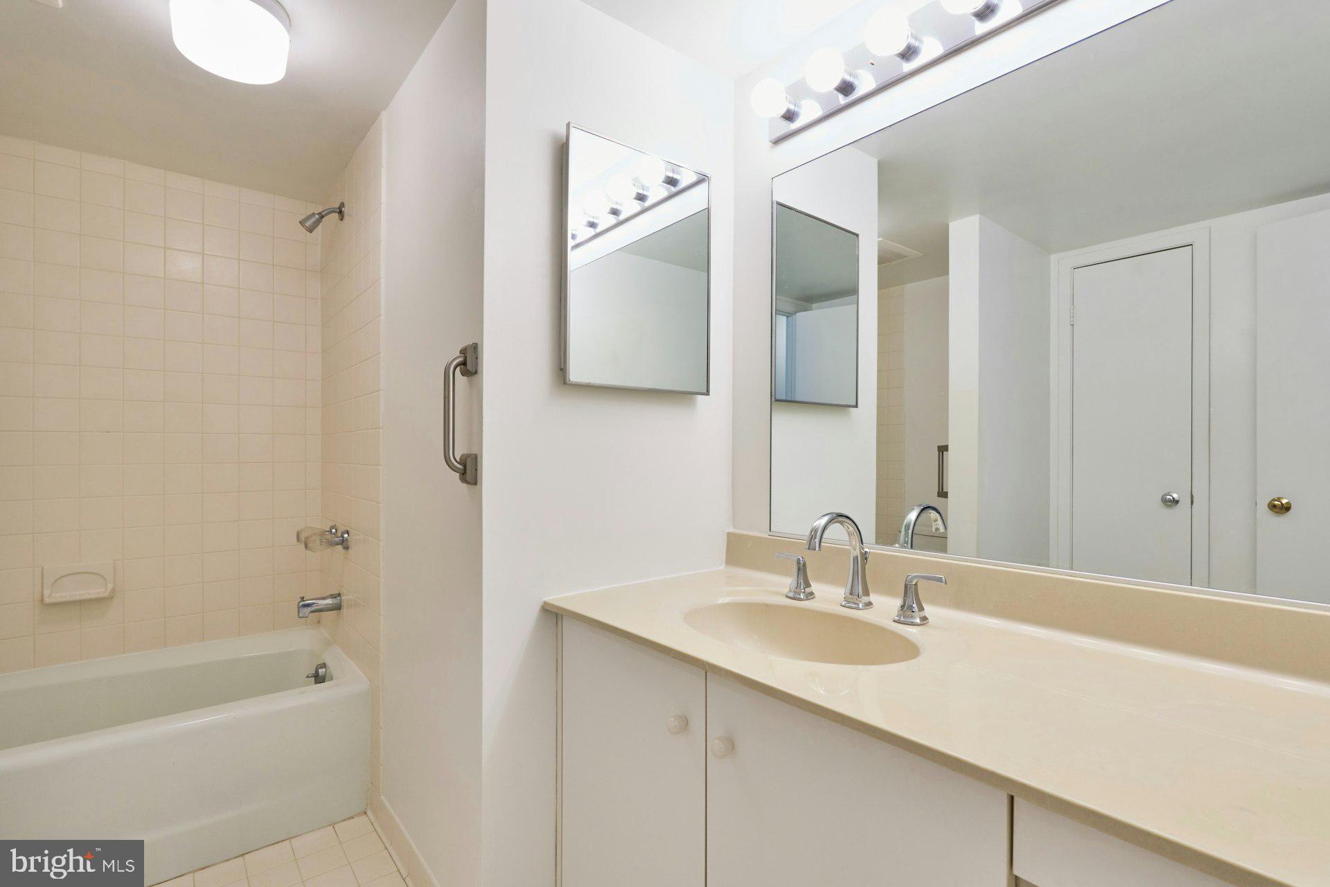 11500 Fairway Drive, Unit 101 Reston, VA 20190 - Photo 29 of 40 a bathroom with a tub sink and mirror