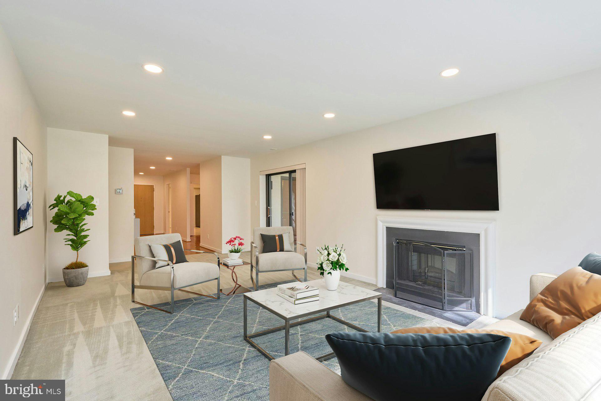 11500 Fairway Drive, Unit 101 Reston, VA 20190 - Photo 7 of 40 a living room with furniture a flat screen tv a lamp and a fireplace