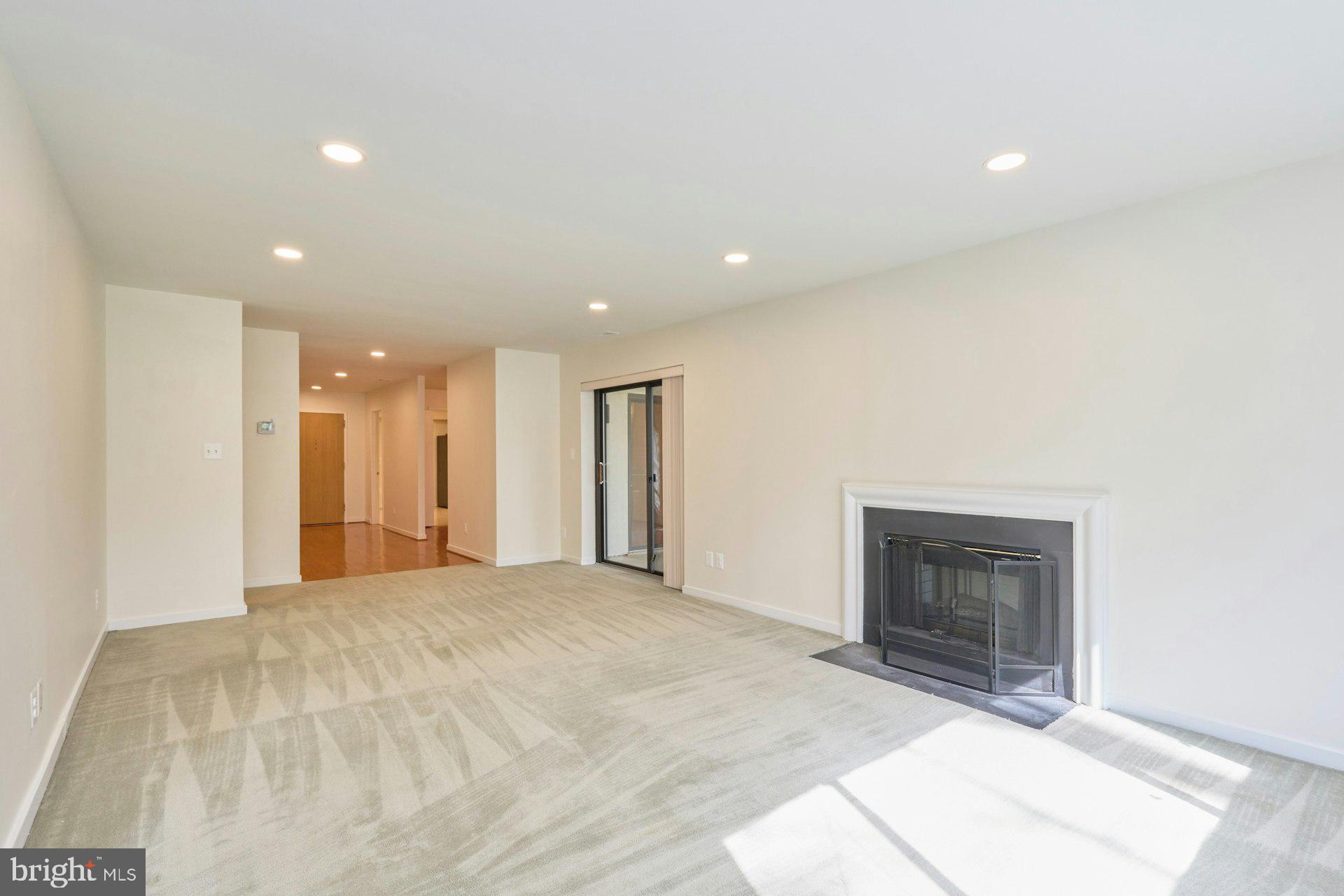 11500 Fairway Drive, Unit 101 Reston, VA 20190 - Photo 10 of 40 a view of an empty room with a fireplace and a window