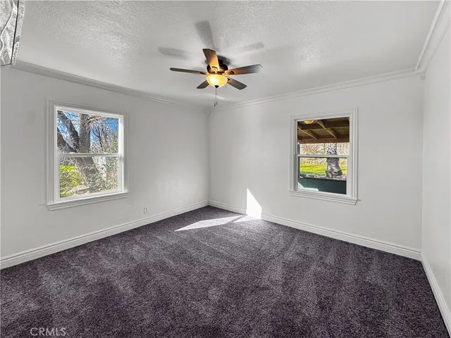 a view of a hallway with a chandelier fan and windows