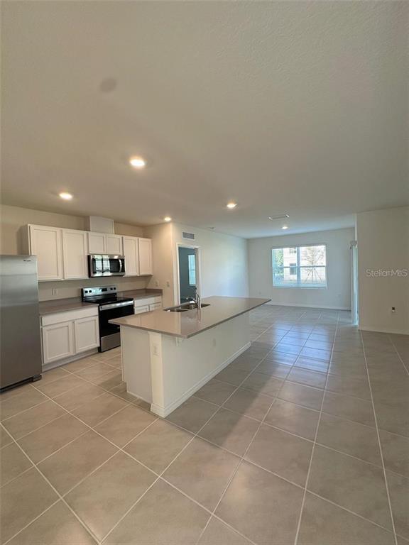 3767 Paragon Lane Clermont, FL 34714 - Photo 11 of 19 a large white kitchen with a large window and white cabinets