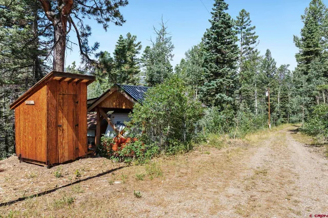a backyard of a house with wooden fence and trees