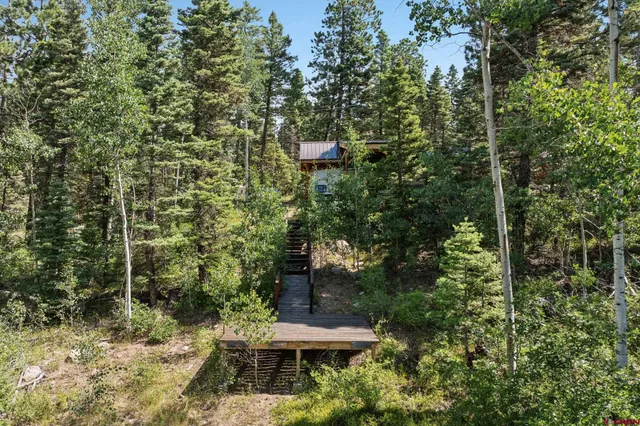 a view of a yard with plants and brick wall