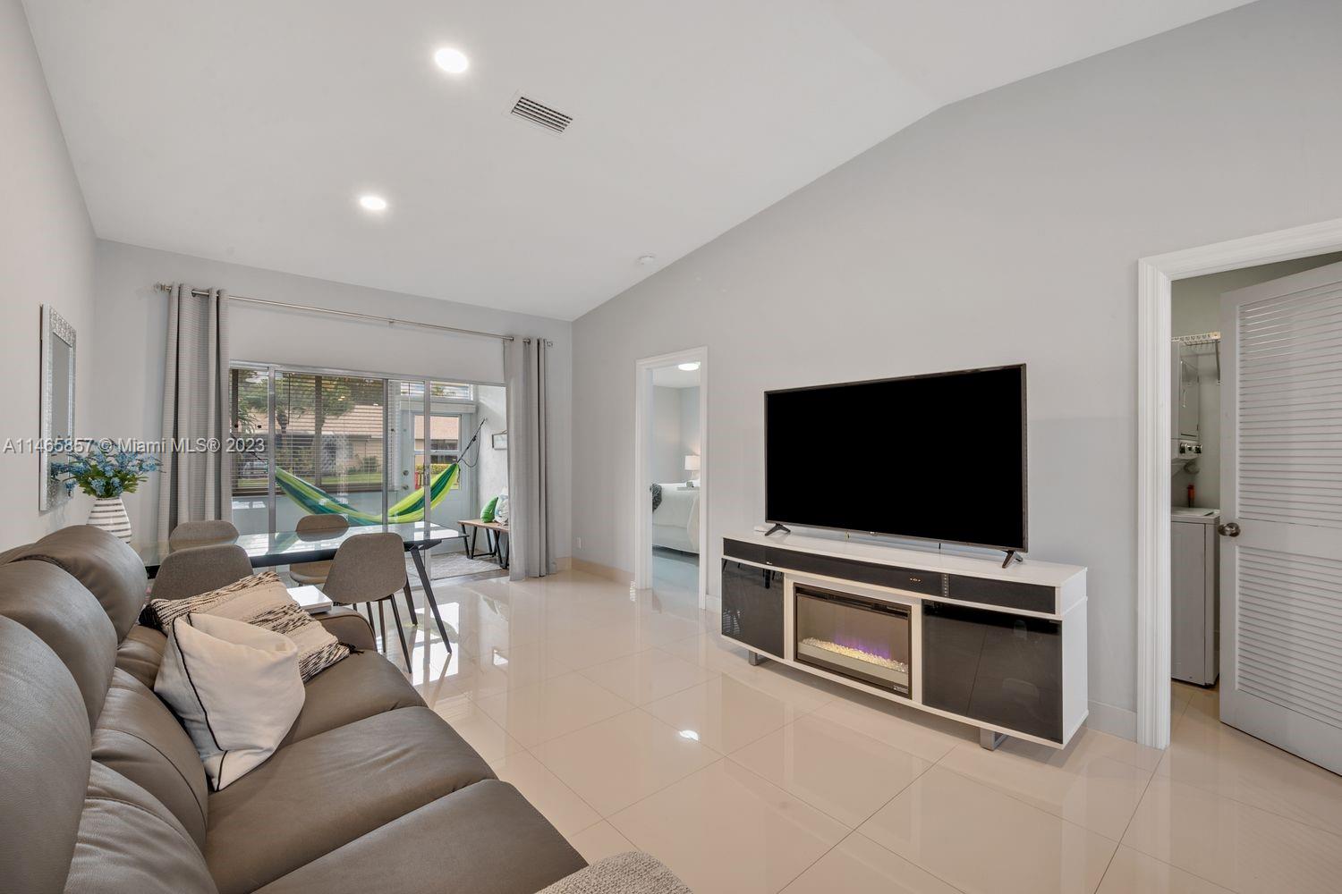 18893 Argosy Drive, Unit 18893 Boca Raton, FL 33496 - Photo 3 of 16 a living room with furniture and a flat screen tv
