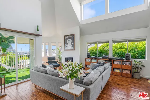 a living room with furniture floor to ceiling window and wooden floor