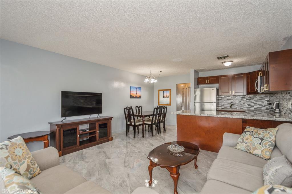 800 Southwest 11th Avenue, Unit 17 Hallandale Beach, FL 33009 - Photo 12 of 18 a living room with furniture and a flat screen tv